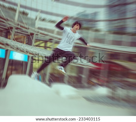 young boy practicing parkour in a urban area. radial blur effect. concept about extreme sports