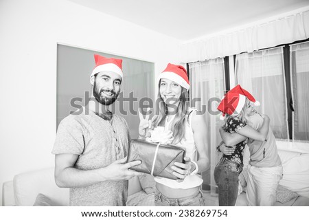 friends sharing christmas present in the living room. concept about christmas and holidays