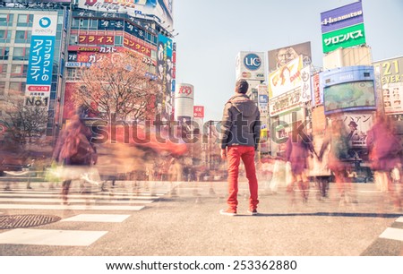 TOKYO,JAPAN - FEBRUARY 11,2015: Man standing in Shibuya square. The scramble crosswalk is one of the largest in the world.