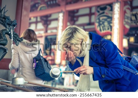 woman drinking water to the holy fountain in Asakusa temple, Tokyo