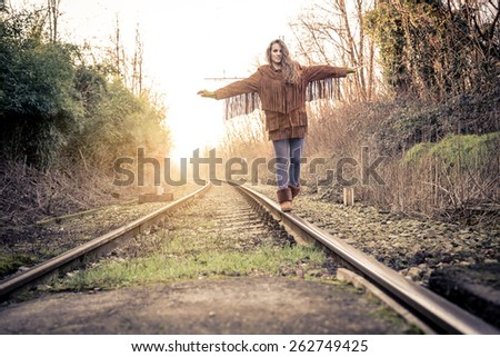 One young woman balancing on rail - Pretty girl walking on rail in search for adrenaline