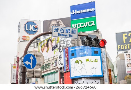 TOKYO, JAPAN - FEBRUARY 10,2015: Street signs and billboards at Shibuya Crossing,Tokyo. The scramble crosswalk is one of the largest in the world.