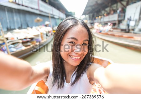 thai girl taking selfie in the bangkok floating market. concept about asia, travels, cultures and people