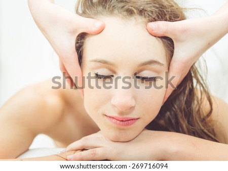 close up on head massage. young woman making head massage. concept about massage saloon, spa, relaxation, beauty and people