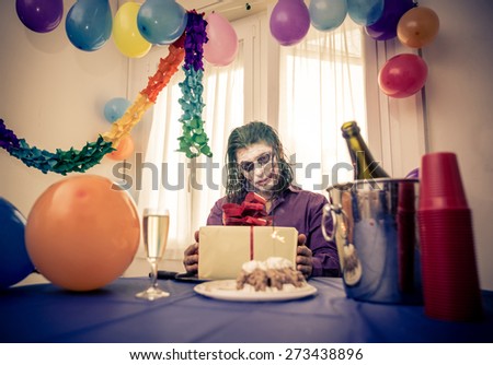 madness party. sad clown sitting alone at his birthday party