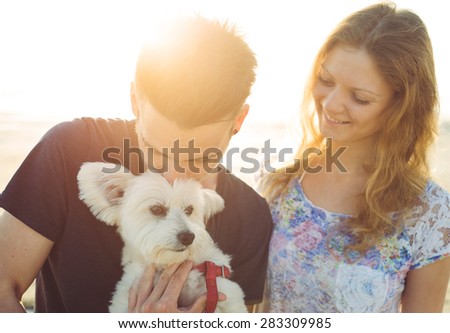 young couple and white dog happily together. couple taking a morning walk with their dog. concept about couples,animals and people