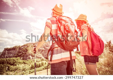 couple on a trekking excursion. they are watching their goal, the top of the mountain. concept about people,nature, leisure and sport