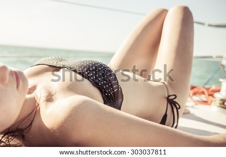 woman getting sun bath on a big boat. concept about beauty and transportation