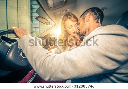 young couple kissing with passion inside a sport car. man holding his woman face and pretend a kiss from her. concept about love, sex, transportation