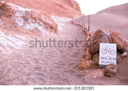A sign says no bikes are allowed on the dune, moon valley, atacama desert