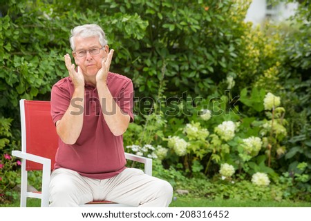 An elderly man is doing a silly face