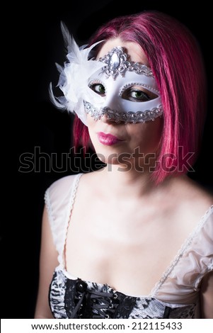 Mysterious red head and green eyed girl with a white mask on black background.