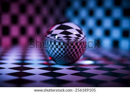 Glass ball on a checkered background.