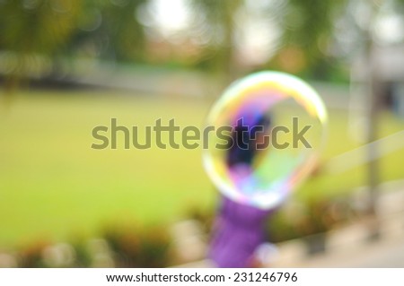 Blur image of children playing giant bubble.