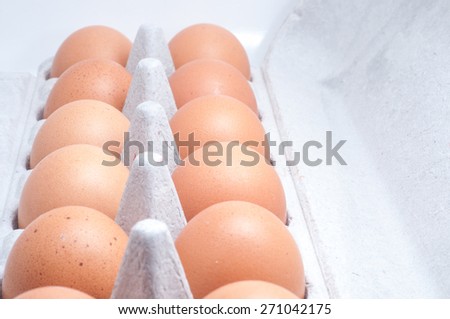 Brown chicken egg on recycle paper tray isolated on white