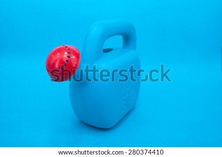 Blue plastic color watering can on blue backgrounds