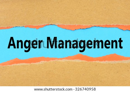 Torn brown and orange paper on blue surface with Anger Management words.