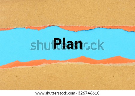 Torn brown and orange paper on blue surface with   Plan words.