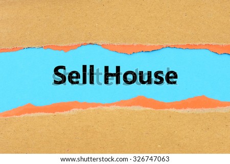 Torn brown and orange paper on blue surface with Sell House words.