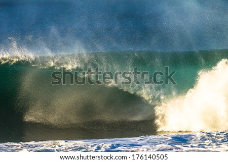 Wave Power Spray Crashing Morning ocean wave crashing onto shallow reefs with power spit spray from water compression in tubing wall of water