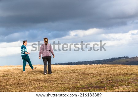 Women Walking Outdoors Countryside Women mother daughter walking away talking outdoors countryside nature reserve
