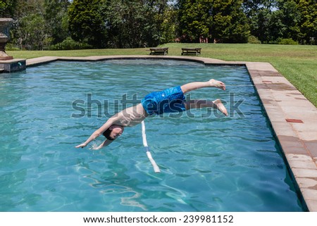 Boy Diving Pool Boy diving into swimming pool water at home summer playtime