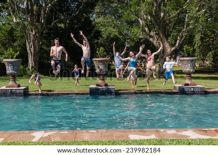 Boys Girls Jump Swim Pool Teen boys girl running jumping into swimming pool water home summer playtime
