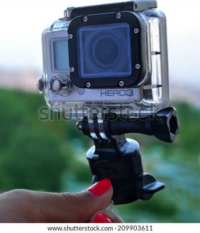 KYIV, UKRAINE - AUGUST 6, 2014: Hand holding small GoPro hero3 camera often used in extreme action video photography.