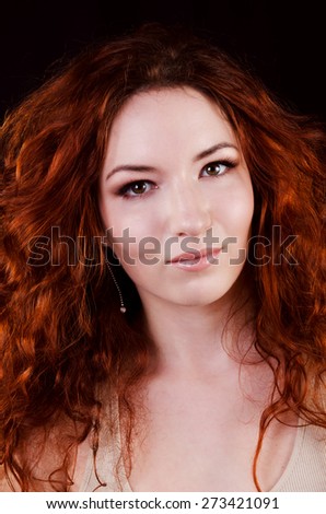 Beautiful young redhead woman with perfect daytime makeup and long silver earrings smiling
