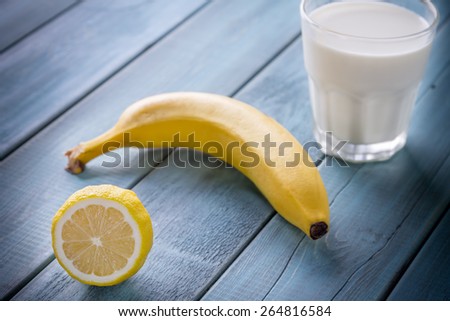 Photo of Lemon, Banana and Milk in Glass on a Vintage Wooden Background
