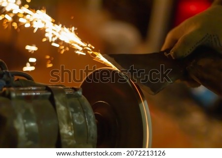 Similar – Image, Stock Photo Worker sharpening axe with electric grinder