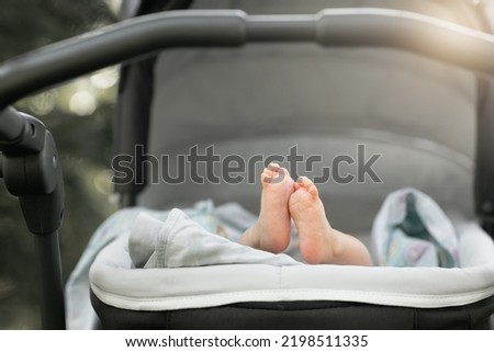 Similar – Image, Stock Photo Baby legs dangling from high chair; baby wearing turquoise outfit with bare feet against white wood background