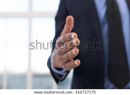 Lets shake hands! Close-up of African businessman stretching out hand for shaking
