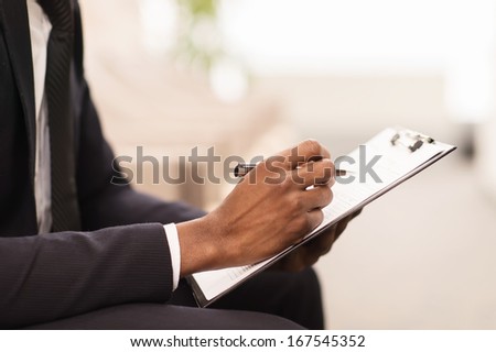 Making notes. Close-up of African man in formalwear writing something in his note pad