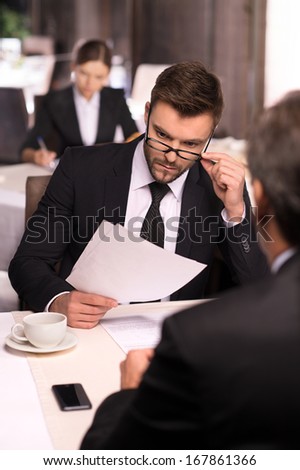 Business people at the restaurant. Business people in formalwear discussing something while sitting at the restaurant
