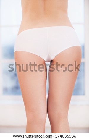 Woman in white panties. Rear view of woman in white panties standing in front of the window