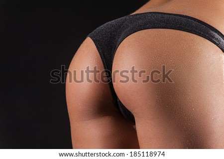 Perfect bum. Close up image of perfect female buttocks against black background