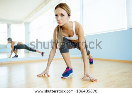 Girl in aerobics class. Beautiful young women in sports clothing exercising and smiling