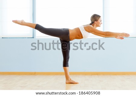 Sports training. Side view of beautiful young woman training in aerobics class