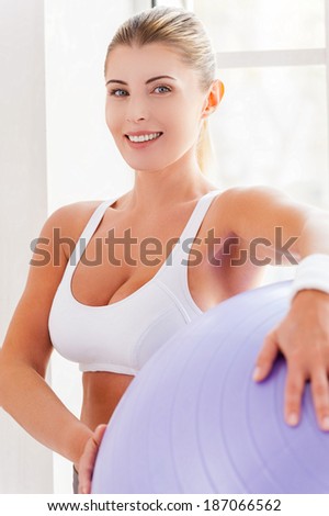 Woman with fitness ball. Attractive mature woman holding fitness ball and smiling at camera