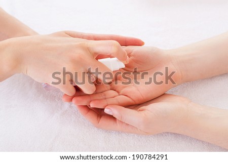 Applying antiseptic. Close-up of manicure master spraying antiseptic on female palm