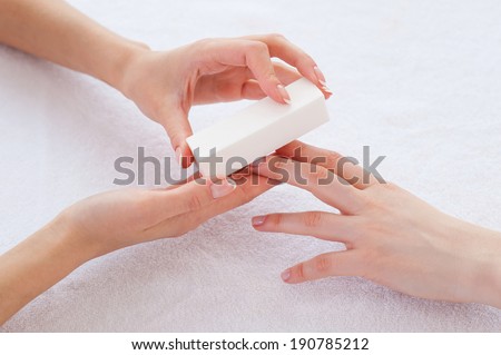 Nail polishing. Close-up top view of beautician polishing nails of female customer