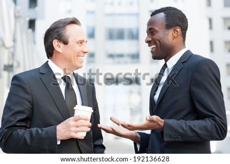 Having a break to talk around. Two cheerful business men talking and gesturing while standing outdoors