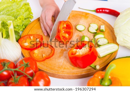 Cutting vegetables. Close-up of woman cutting vegetable on the cutting board