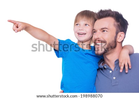 What is there? Side view of happy father and son looking away while child pointing away and both standing isolated on white