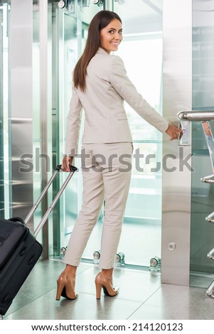 Ready to new business trip. Rear view of confident young businesswoman in formalwear pushing button while standing near elevator entrance