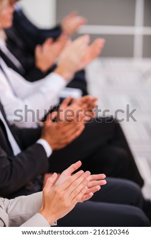 People applauding. Group of business people clapping hand while sitting in a row