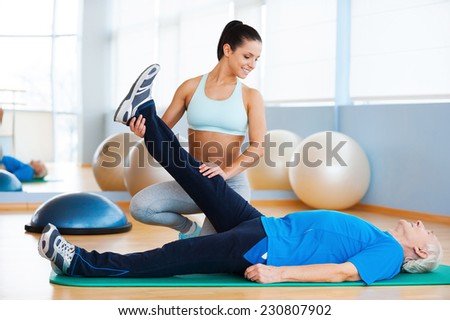 Physiotherapy. Confident female physical therapist working with senior man in health club