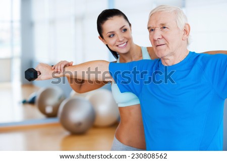 You are making progress! Confident female physical therapist working with senior man in health club