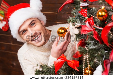 Decorating Christmas Tree. Close-up of man decorating Christmas Tree with Christmas Balls